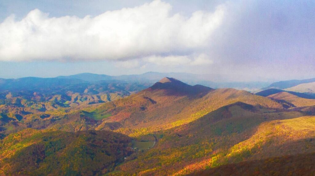 Elk Knob State Park in Fall all the leaves have turned colors and you have a view of the knob piercing the clouds