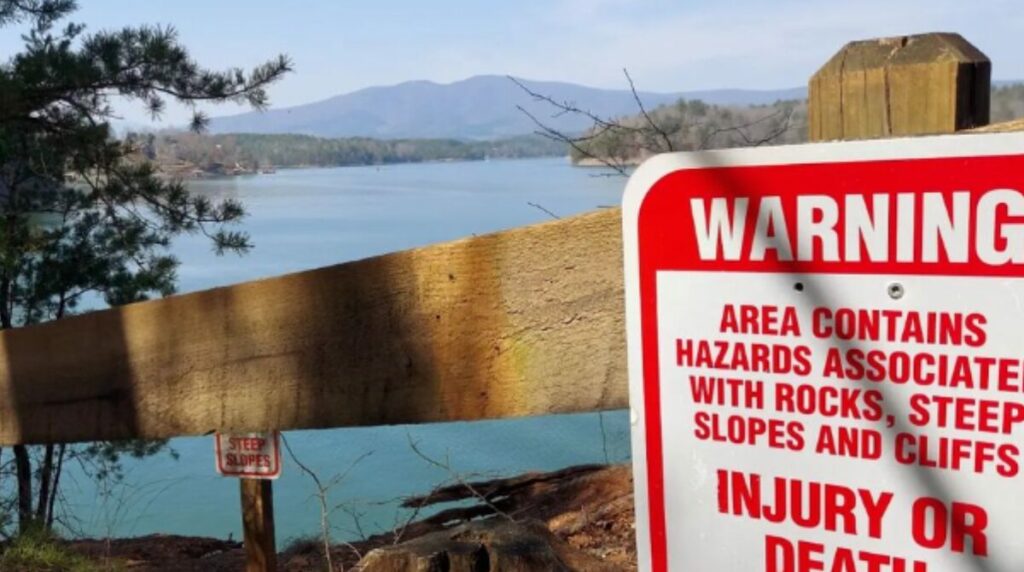 warning sign mountains in background behind lake james at lake james state park