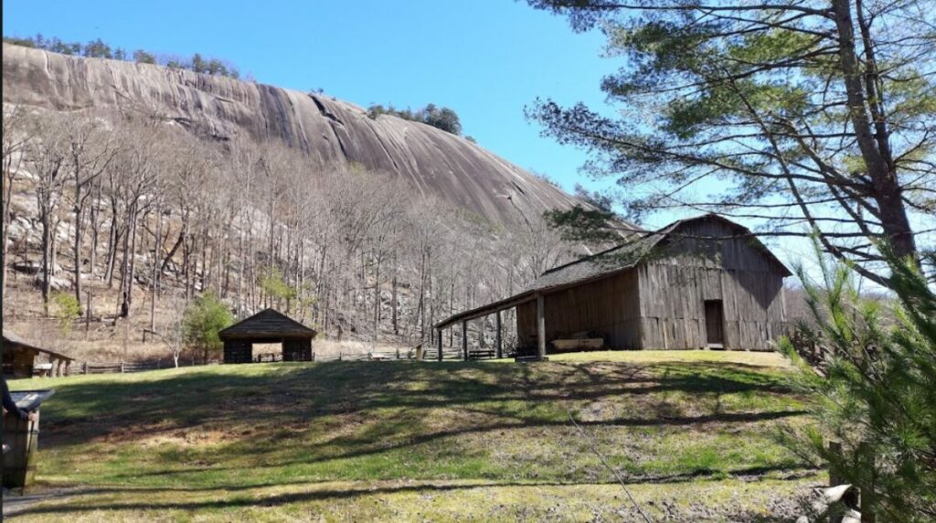 Stone Mountain in the background with the barn and some outbuildings from the Homestead in the foreground at Stone Mountain State Park